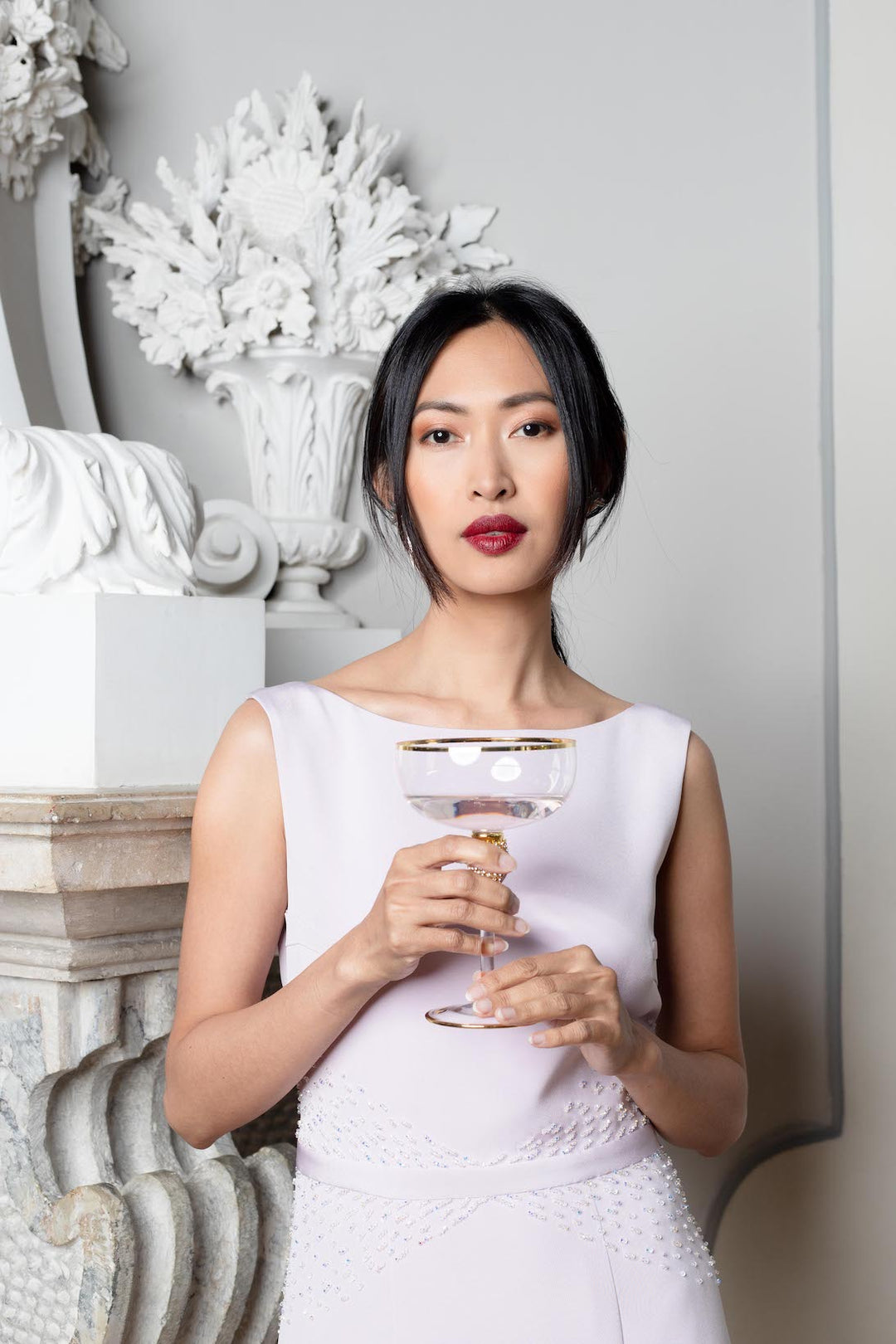 An elegant woman is wearing the luxurious lilac cocktail dress, embroidered with crystals