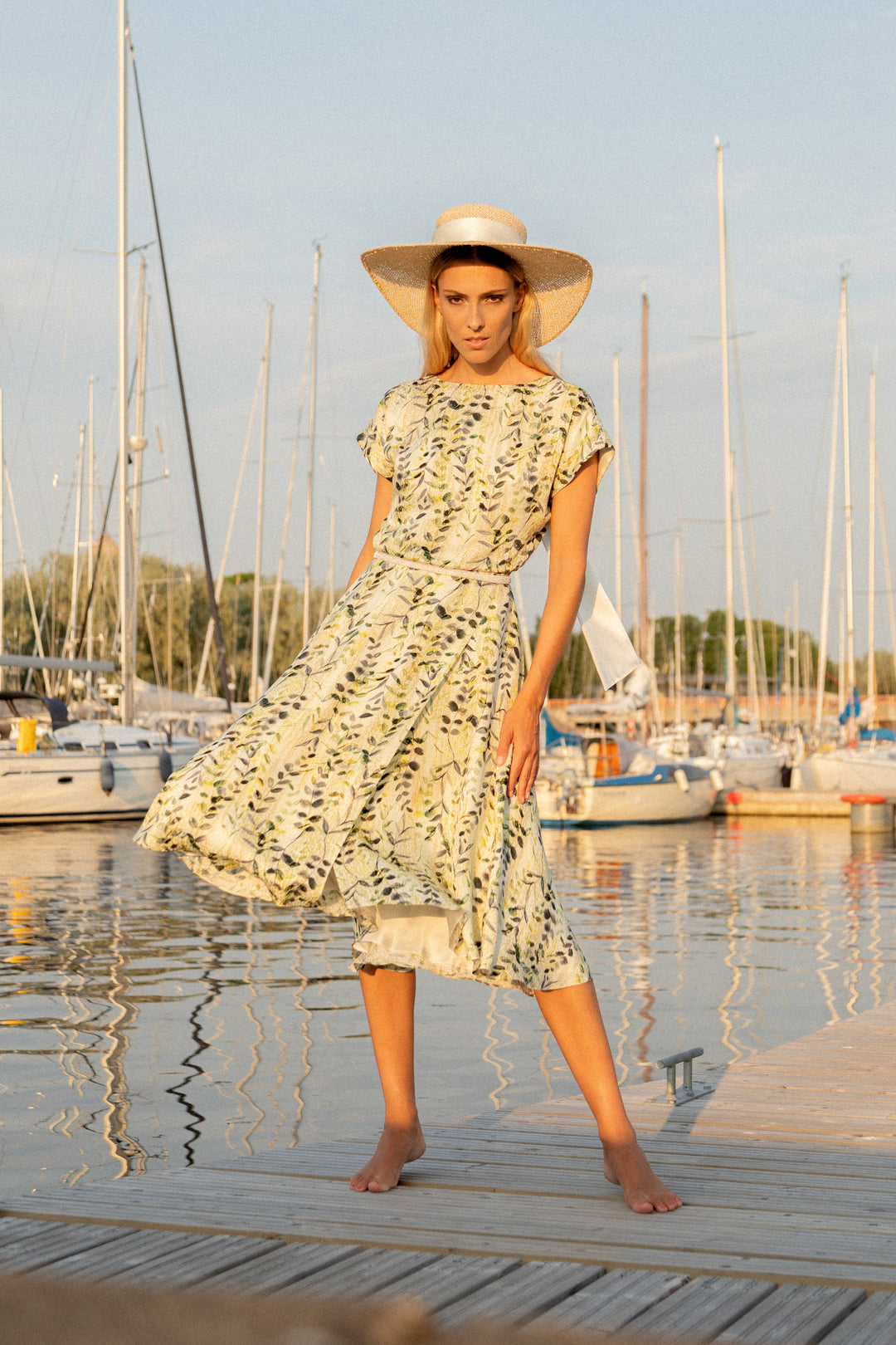 A Blond women is wearing Marimo's Olive pattern Leibnitzia summer cocktail dress