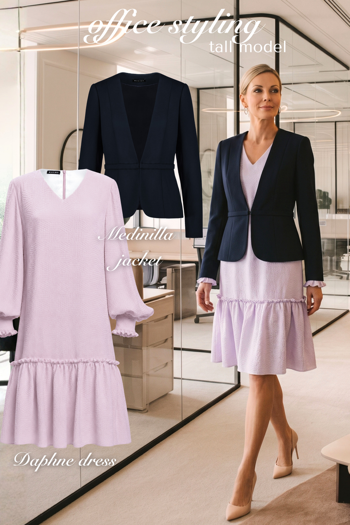 AI generated CEO woman wearing a lavender silk a-line dress and navy fine wool tailored blazer in an office setting with the product photos of the blazer and dress next to her.