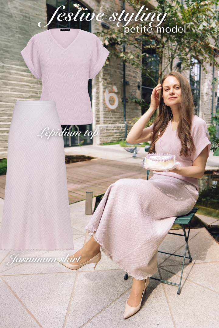 Petite woman sitting in a lavender silk monochrome outfit of a midi skirt and t-shirt with the product photos next to her.