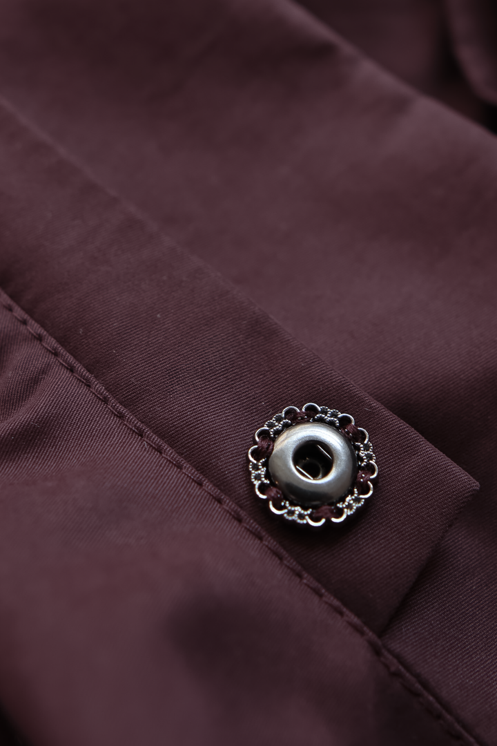 Detail of press button fastening on a minimalist luxury trench jacket.